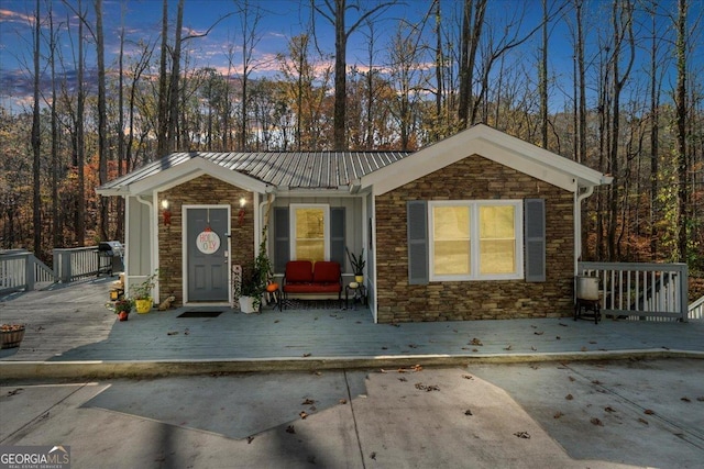 173 Mountainside Dr E, Dawsonville, GA 30534 - view of front of property featuring stone siding, a wooden deck, and metal roof