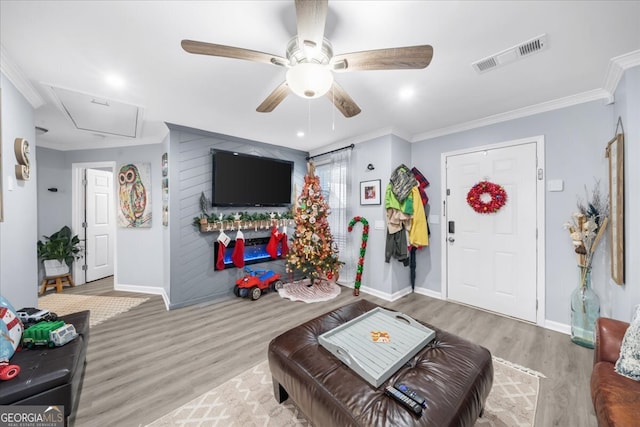 living room with crown molding, hardwood / wood-style floors, and ceiling fan