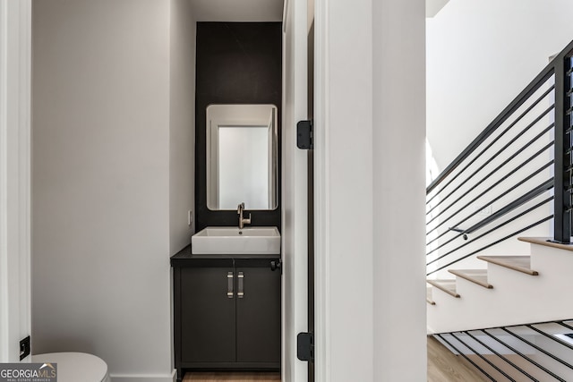 bathroom featuring hardwood / wood-style flooring, vanity, and toilet