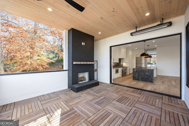 interior space featuring an outdoor kitchen, sink, and a fireplace