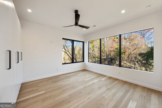 spare room with ceiling fan and light wood-type flooring