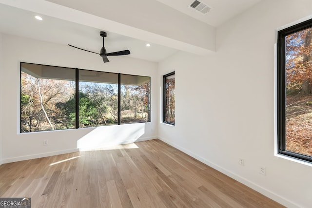 spare room featuring ceiling fan, light hardwood / wood-style floors, and a wealth of natural light