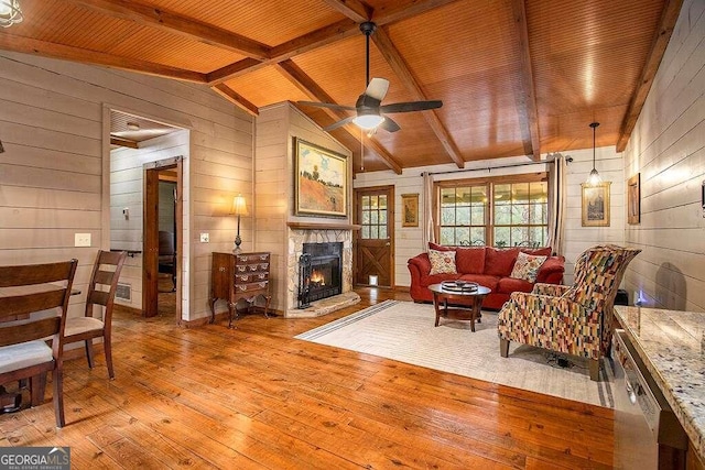 living room featuring ceiling fan, wooden ceiling, lofted ceiling with beams, wood walls, and light wood-type flooring