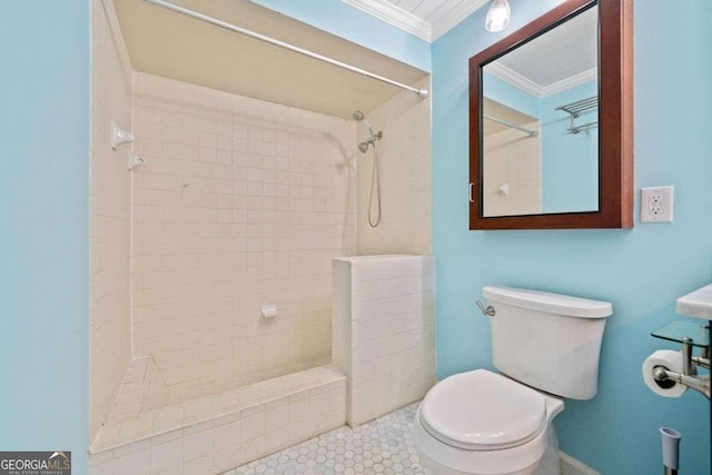 bathroom with tiled shower, tile patterned floors, ornamental molding, and toilet