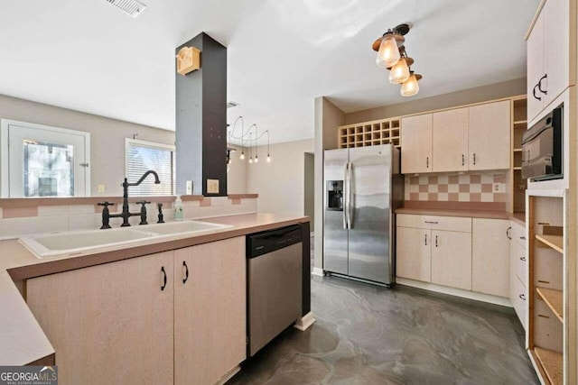 kitchen with cream cabinetry, decorative backsplash, sink, and appliances with stainless steel finishes