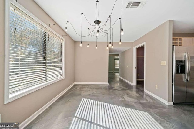 unfurnished dining area featuring a notable chandelier