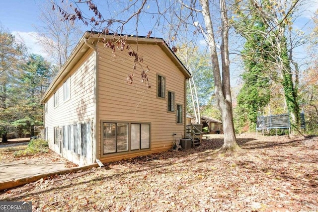 view of home's exterior with a trampoline and cooling unit