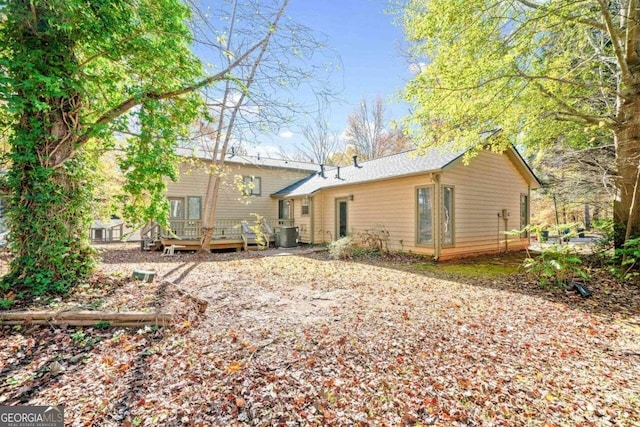 back of house featuring central AC unit and a deck