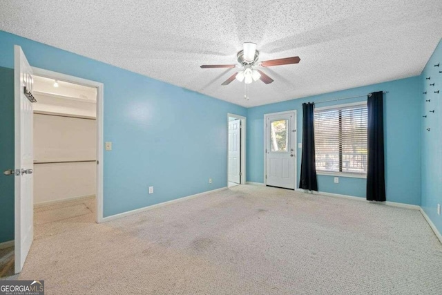 carpeted empty room featuring ceiling fan and a textured ceiling