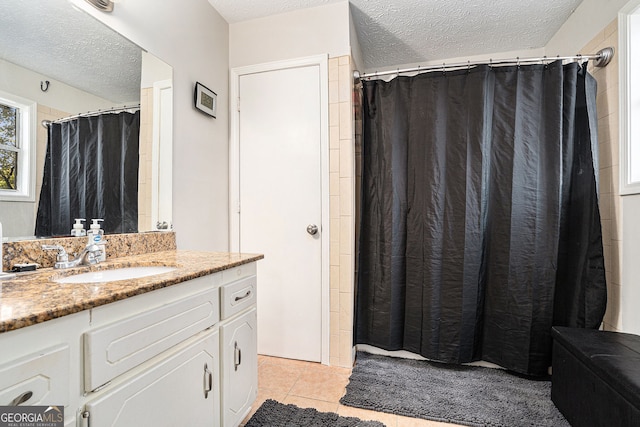 bathroom featuring tile patterned floors, vanity, and a textured ceiling