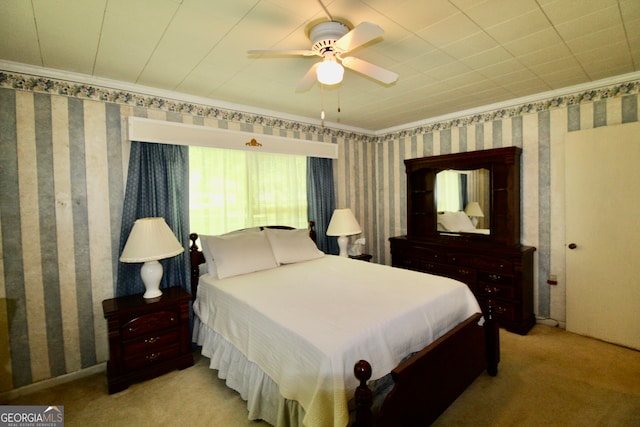 carpeted bedroom with ceiling fan and ornamental molding