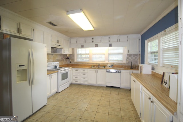 kitchen with white appliances, white cabinetry, and plenty of natural light