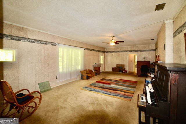 living area featuring light carpet, a textured ceiling, and ceiling fan