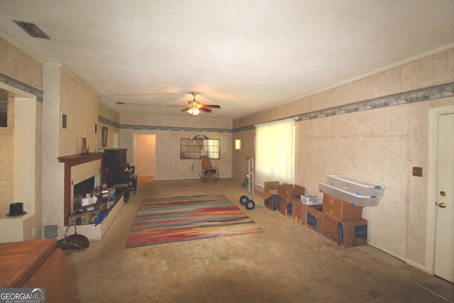 carpeted living room featuring ceiling fan, a textured ceiling, and ornamental molding