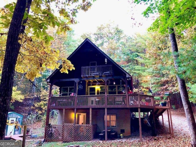 back of property with a balcony and a wooden deck