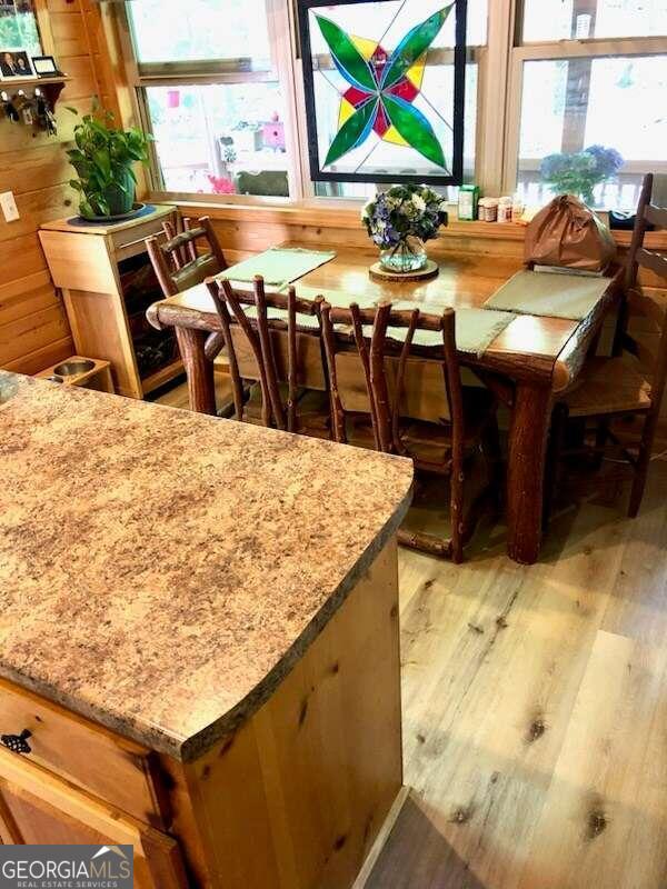 dining room featuring light hardwood / wood-style flooring and wood walls