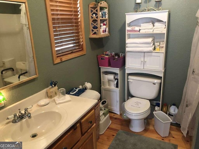 bathroom featuring a shower with curtain, toilet, vanity, and hardwood / wood-style flooring