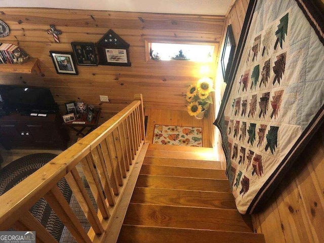 stairs with hardwood / wood-style floors and wood walls