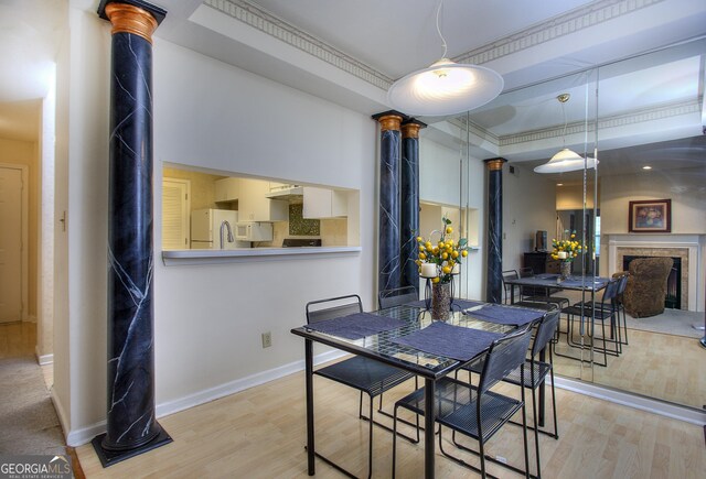 dining area with light hardwood / wood-style floors and crown molding