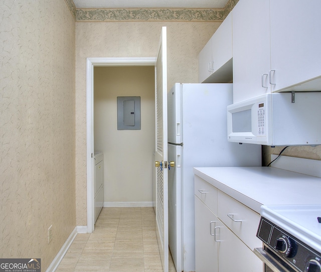 kitchen with light countertops, stove, white microwave, white cabinetry, and electric panel