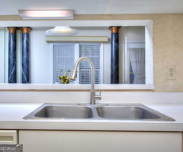 interior details featuring a sink and a textured wall