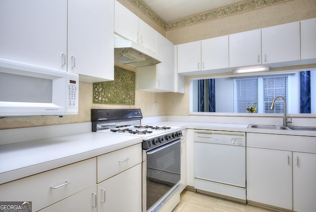 kitchen featuring white appliances, light countertops, under cabinet range hood, white cabinetry, and a sink