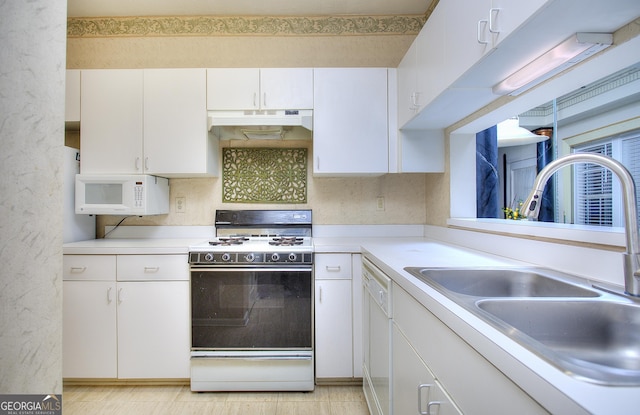 kitchen with under cabinet range hood, white appliances, a sink, white cabinetry, and light countertops