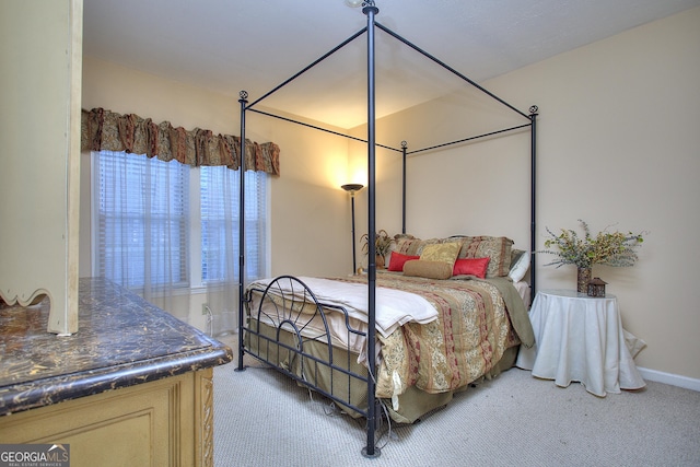 bedroom with light carpet and baseboards