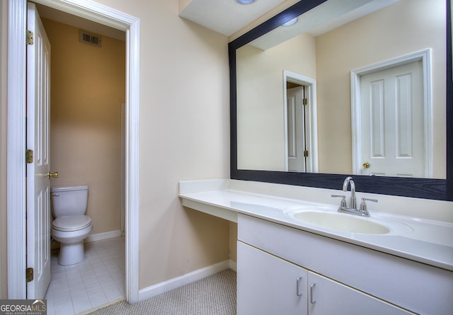 bathroom with toilet, vanity, visible vents, baseboards, and tile patterned floors