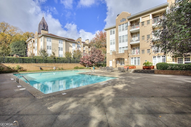 pool with fence and a patio