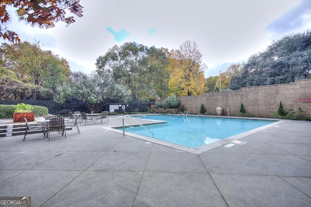 pool featuring fence and a patio