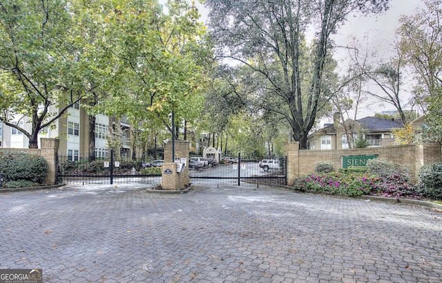 view of street featuring a gate, curbs, and a gated entry