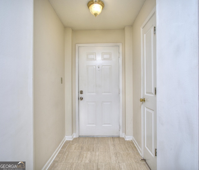 doorway to outside with baseboards