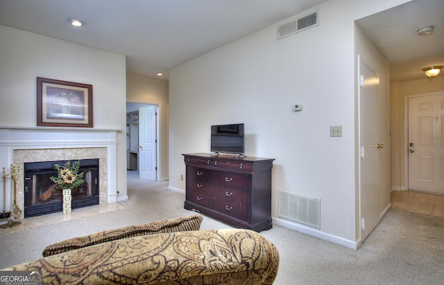 bedroom featuring light carpet, baseboards, a fireplace, and visible vents