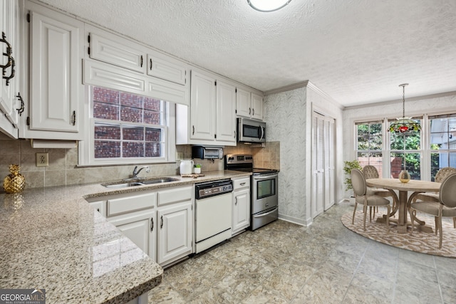 kitchen with white cabinetry, sink, hanging light fixtures, stainless steel appliances, and a textured ceiling