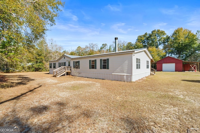 view of front of house featuring a garage, an outdoor structure, and a front lawn