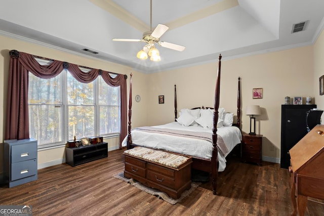 bedroom with a raised ceiling, crown molding, ceiling fan, and dark wood-type flooring