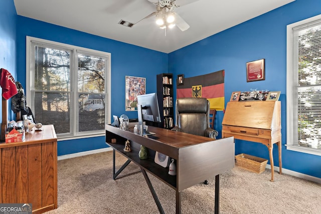 carpeted office with a wealth of natural light and ceiling fan