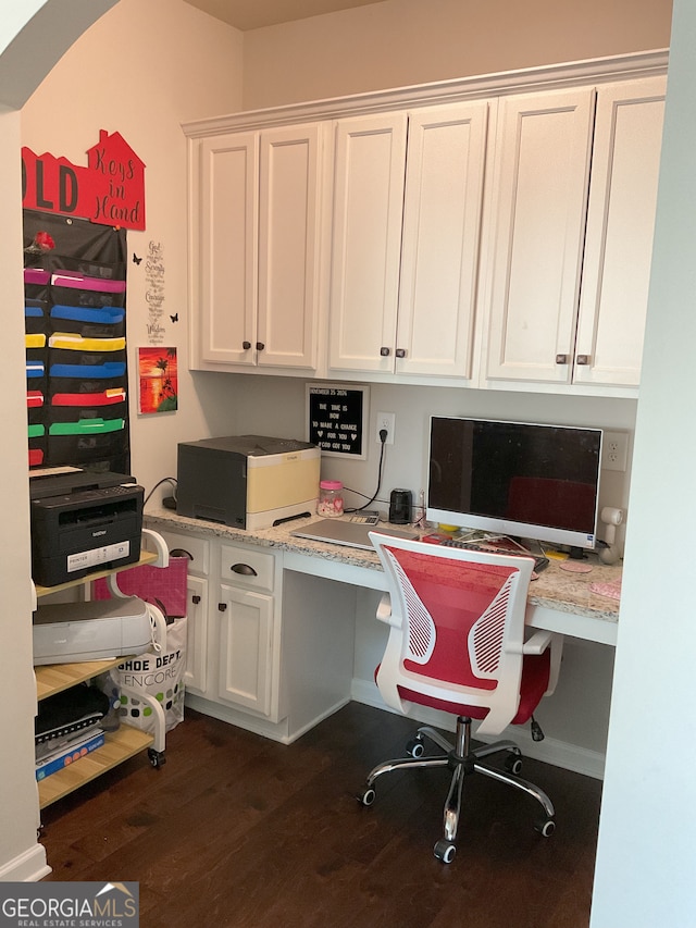 home office with built in desk and dark hardwood / wood-style floors