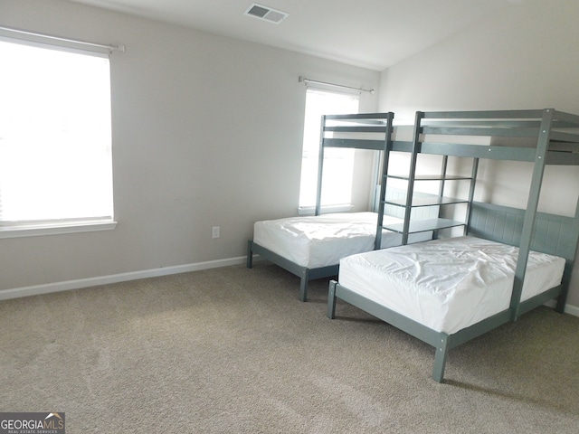 carpeted bedroom featuring multiple windows