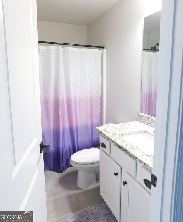 bathroom featuring walk in shower, tile patterned flooring, vanity, and toilet