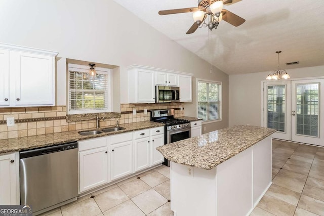 kitchen featuring appliances with stainless steel finishes, a center island, white cabinetry, and plenty of natural light