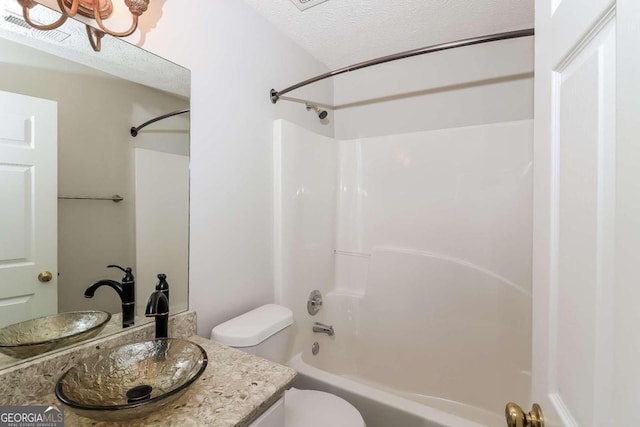 full bathroom with bathing tub / shower combination, vanity, a textured ceiling, and toilet