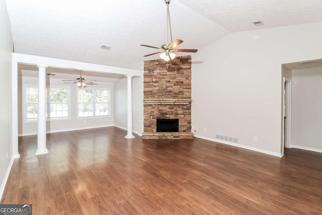 unfurnished living room featuring dark wood-type flooring, vaulted ceiling, ceiling fan, a textured ceiling, and a fireplace