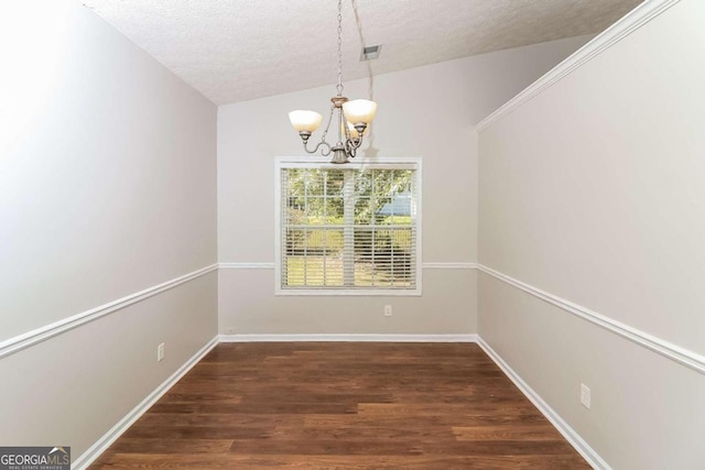 unfurnished dining area featuring dark hardwood / wood-style flooring, a textured ceiling, lofted ceiling, and a notable chandelier