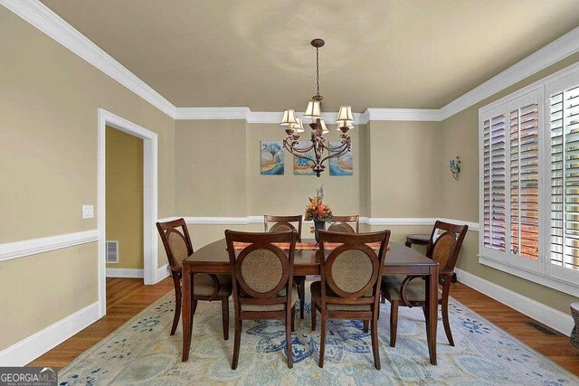 dining area featuring a notable chandelier, a healthy amount of sunlight, and wood-type flooring