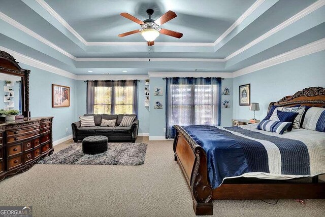 bedroom featuring crown molding, light carpet, and a tray ceiling