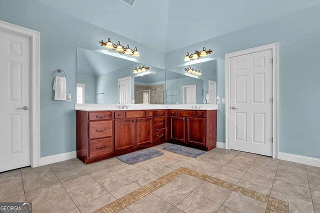 bathroom with tile patterned flooring, vanity, a shower with door, and vaulted ceiling