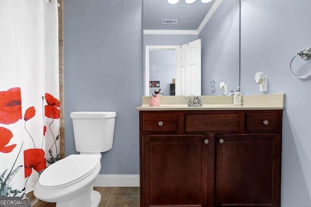 bathroom with tile patterned floors, vanity, toilet, and ornamental molding