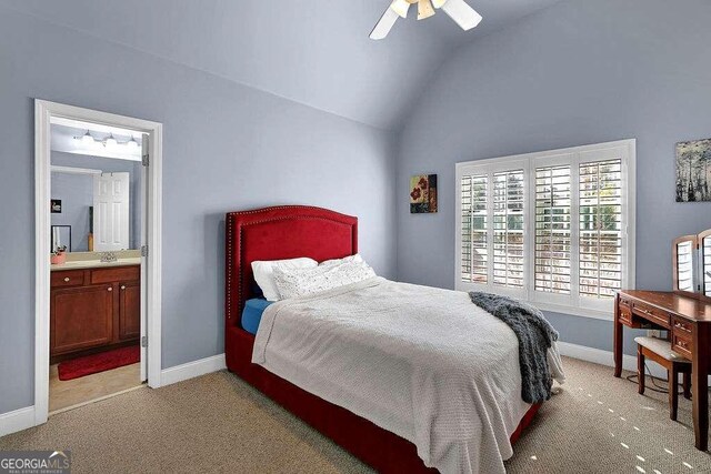 bedroom featuring lofted ceiling, ensuite bathroom, sink, ceiling fan, and light colored carpet